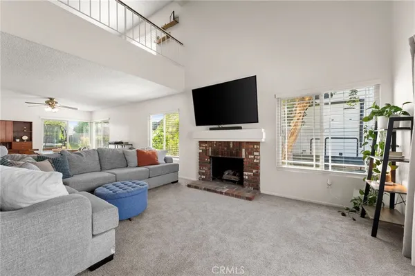 a living room with furniture a flat screen tv and a fireplace