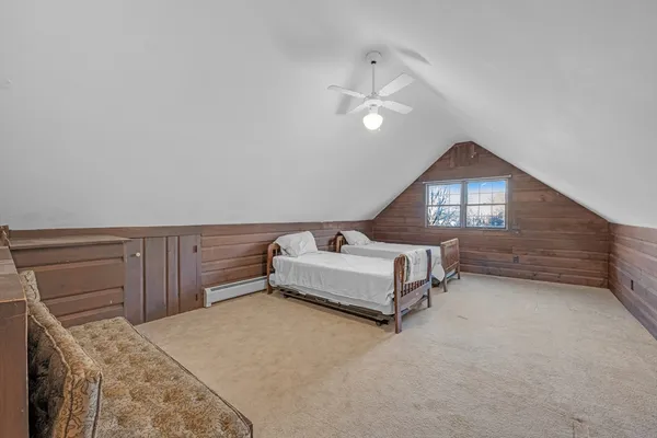 a spacious bedroom with a bed and a dresser