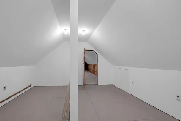 a spacious bedroom with a bed and a chandelier