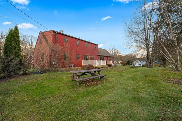 a view of a house with a big yard and large trees