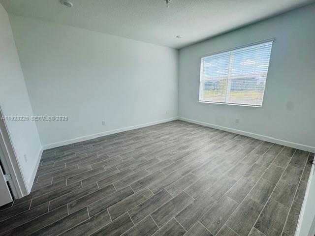 19552 Whispering Creek Road, Unit 1 West Palm Beach, FL 33470 - Photo 13 of 16 an empty room with wooden floor and windows