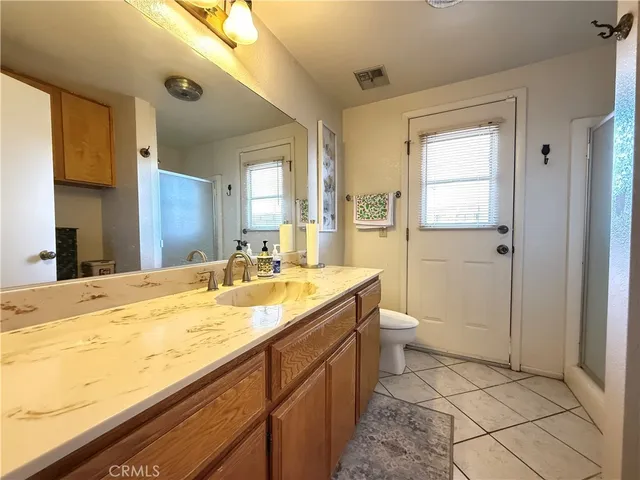 a bathroom with a granite countertop sink toilet and shower