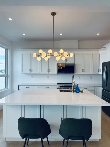 a kitchen with stainless steel appliances a stove a sink a refrigerator and a counter space