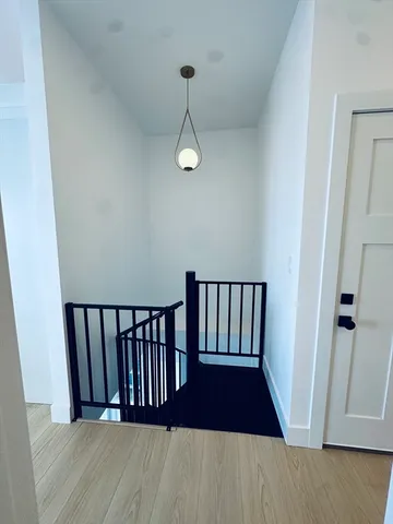 an empty room with wooden floor and a ceiling fan