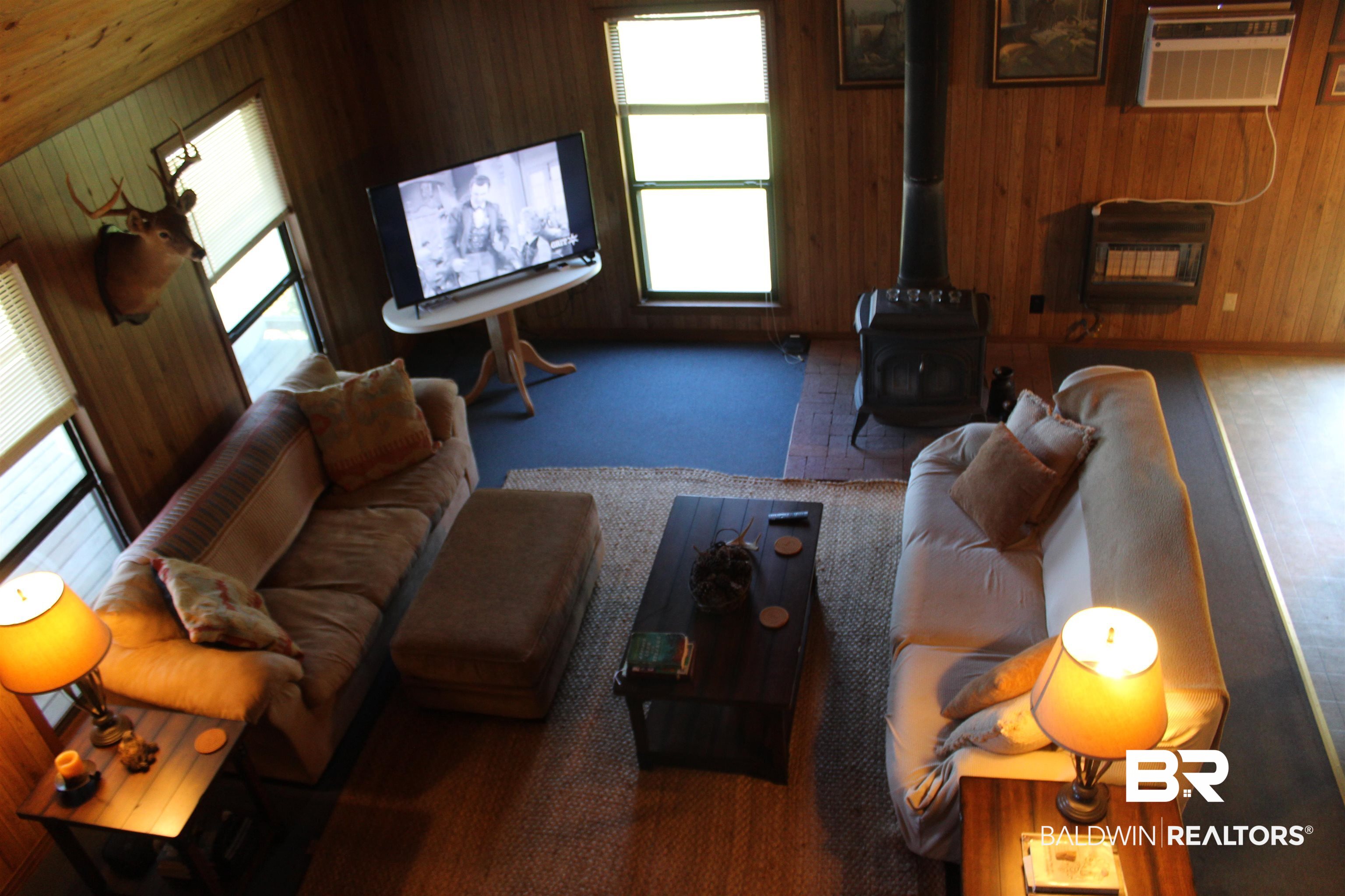 6447 Henderson Road Lowndesboro, AL 36752 - Photo 13 of 22 Carpeted living area with a wood stove, heating unit, and wood walls