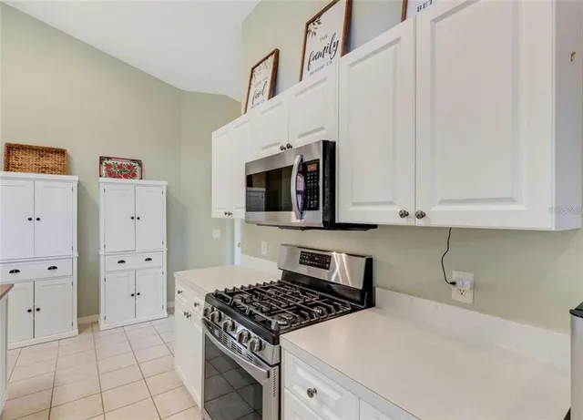 a kitchen with white cabinets and appliances