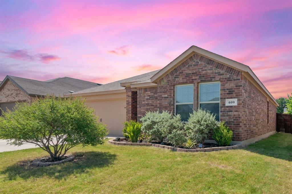 409 Wilson Way Denton, TX 76207 - Photo 1 of 33 Brick exterior with a gabled roofline and a two-car garage