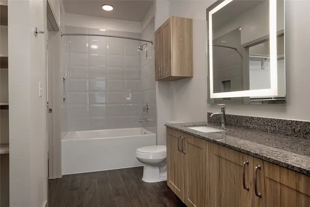 a bathroom with a granite countertop sink toilet and shower