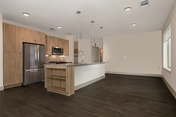 a kitchen with a refrigerator and a stove top oven