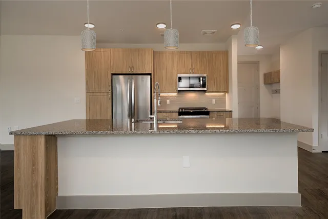 a kitchen with kitchen island a counter space a sink appliances and cabinets