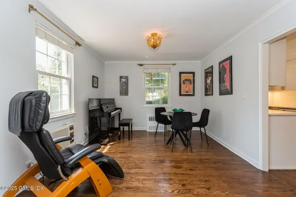 a bedroom with a bed and dresser with wooden floor