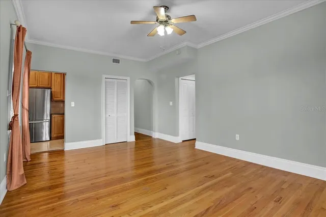 a view of an empty room with wooden floor