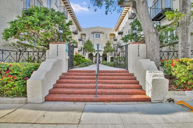 a front view of a house with plants and garden