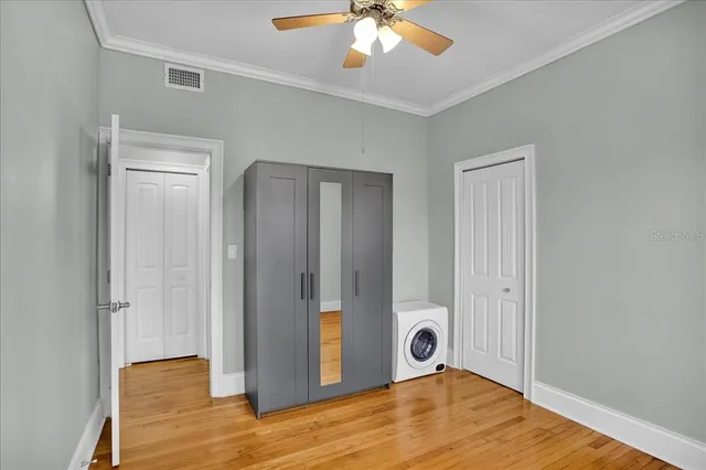 a view of an empty room with wooden floor