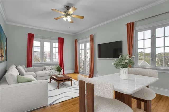 a living room with furniture a flat screen tv and a large window
