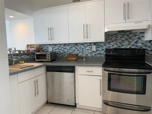 a kitchen with granite countertop white cabinets and white appliances