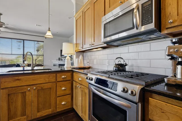 a kitchen with stainless steel appliances granite countertop a stove and a microwave