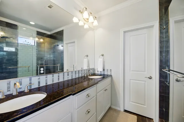 a spacious bathroom with a granite countertop sink a mirror and a shower