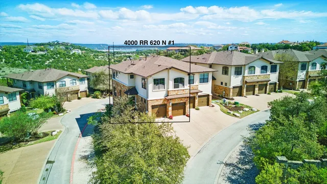 an aerial view of a house with a garden and lake view