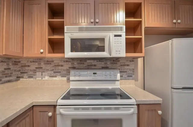 a view of a kitchen with cabinets and stainless steel appliances