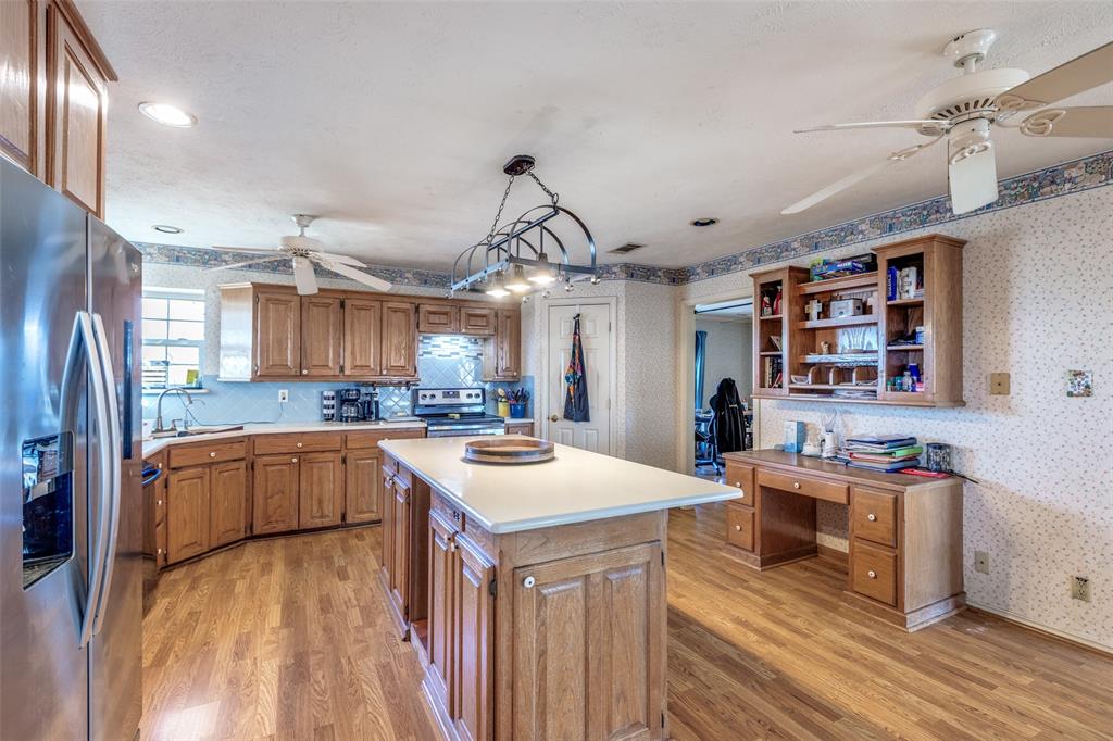 453 County Road 371 Anna, TX 75409 - Photo 12 of 26 a kitchen that has a lot of cabinets a sink and wooden floor