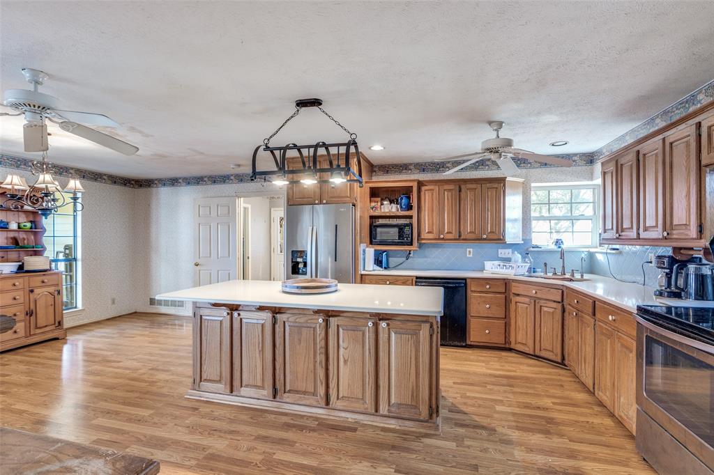453 County Road 371 Anna, TX 75409 - Photo 15 of 26 a large kitchen with kitchen island a sink and a stove top oven