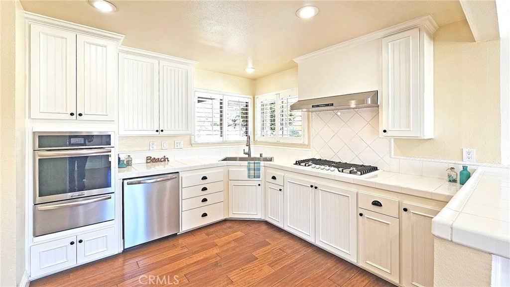 25276 Barque Way Dana Point, CA 92629 - Photo 21 of 61 a kitchen with granite countertop white cabinets and white appliances