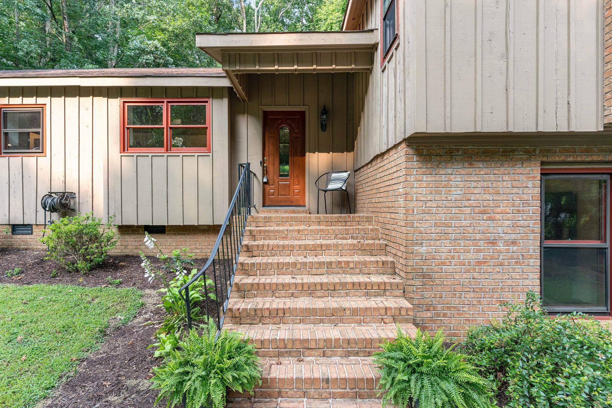 a view of a house with potted plants and a table chair