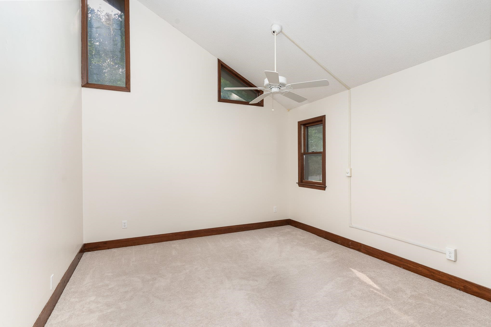 9413 Springdale Drive Raleigh, NC 27613 - Photo 14 of 24 an empty room with a ceiling fan and carpet