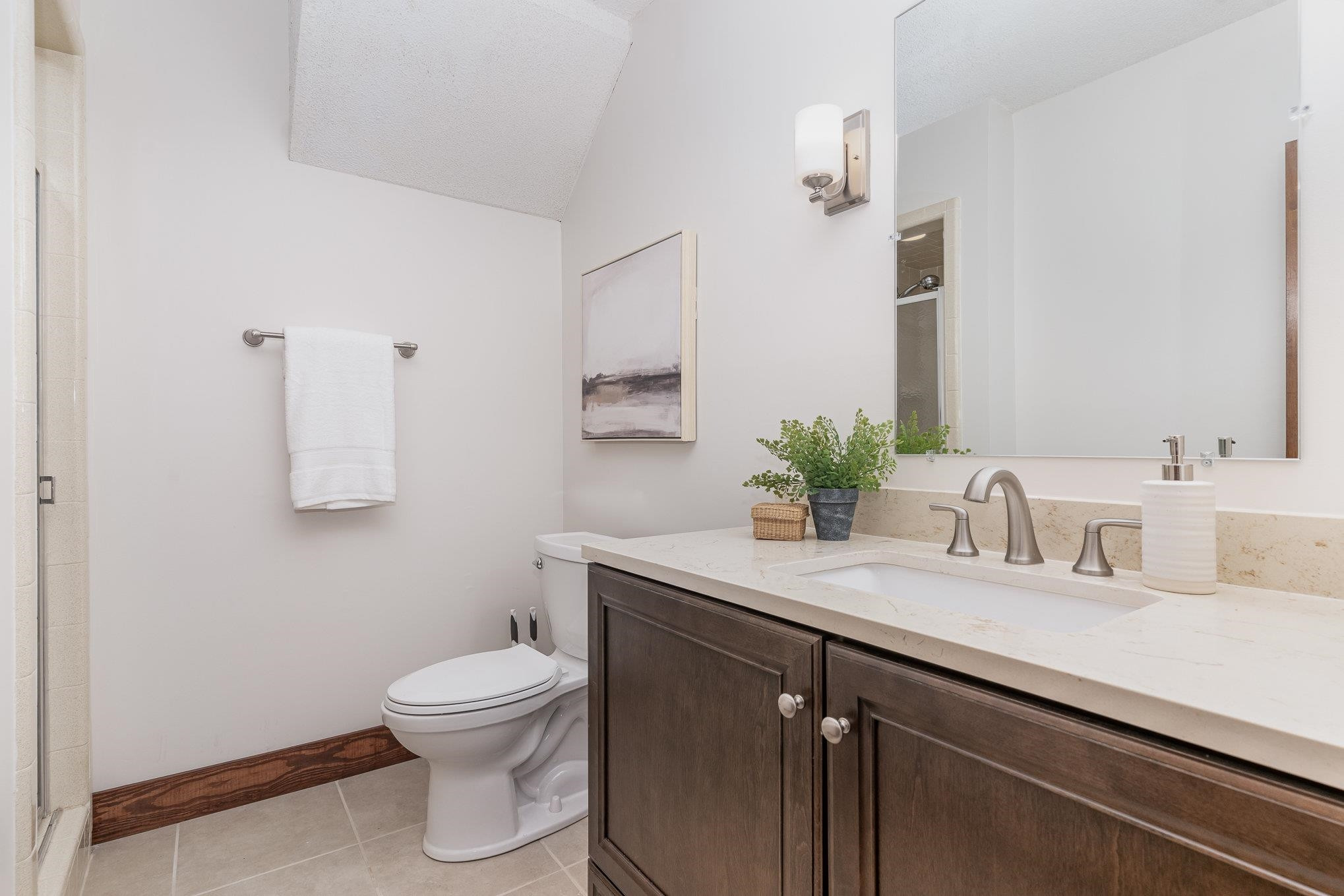 9413 Springdale Drive Raleigh, NC 27613 - Photo 21 of 24 a bathroom with a granite countertop sink a toilet and a mirror