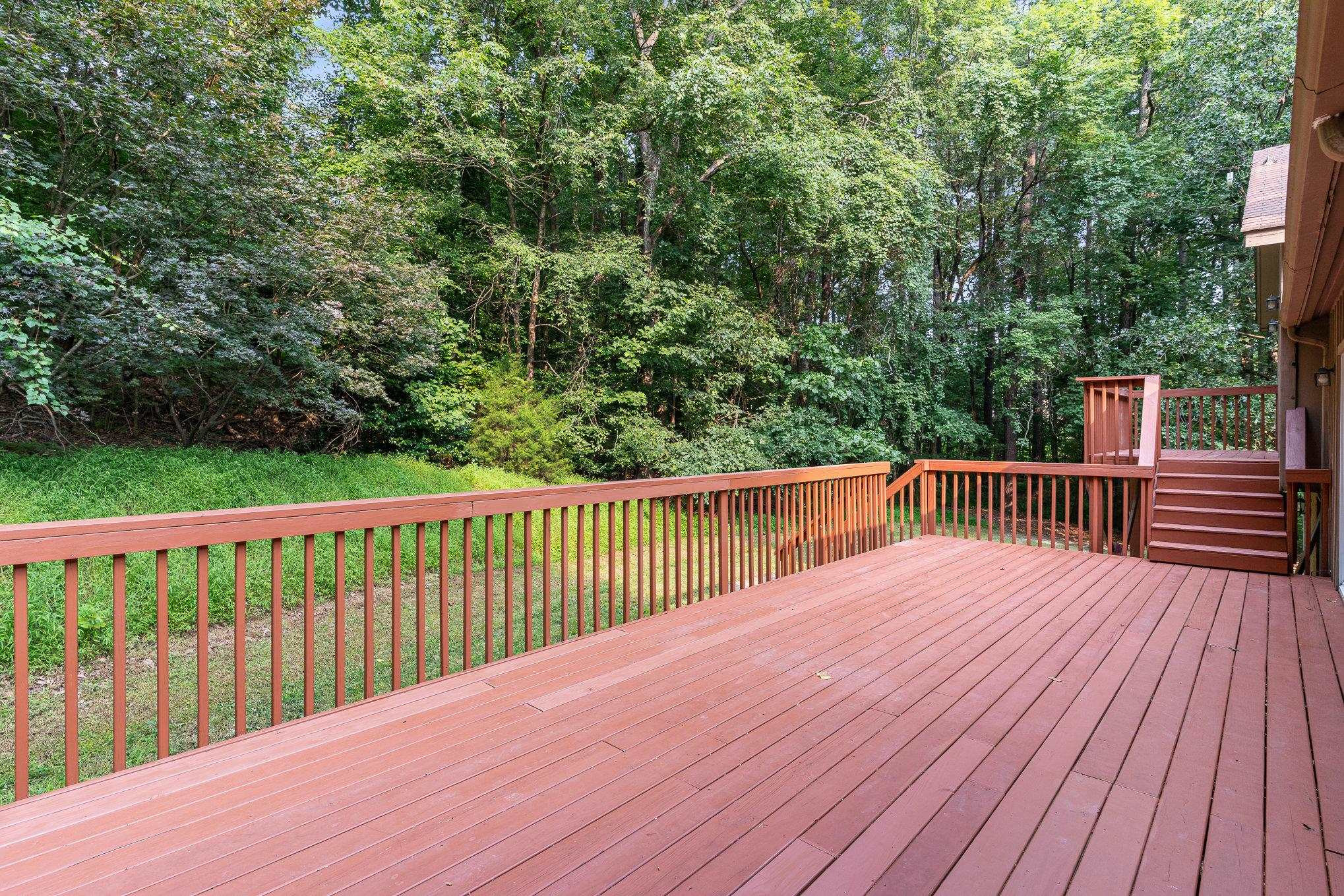 9413 Springdale Drive Raleigh, NC 27613 - Photo 22 of 24 a balcony with wooden floor and trees in the back