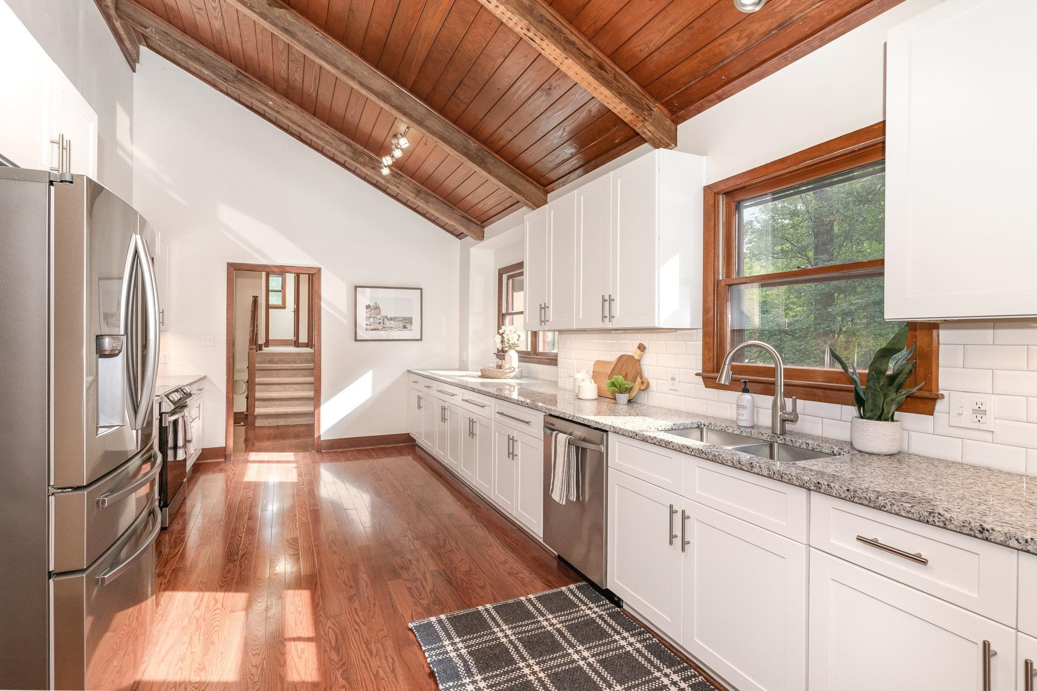9413 Springdale Drive Raleigh, NC 27613 - Photo 4 of 24 a large kitchen with granite countertop a large window a sink and stainless steel appliances