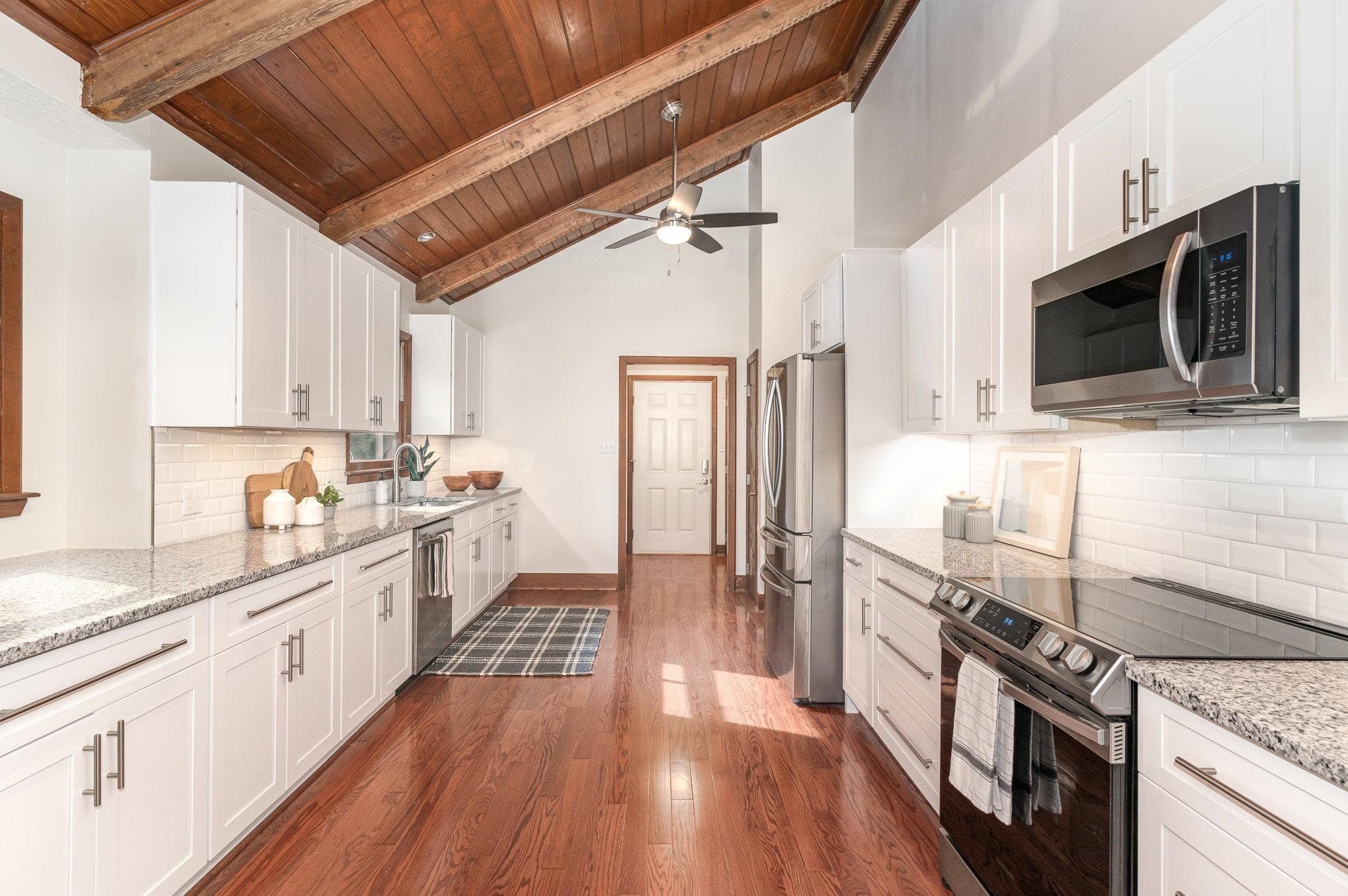 9413 Springdale Drive Raleigh, NC 27613 - Photo 5 of 24 a kitchen with granite countertop a stove top oven a sink dishwasher a refrigerator and cabinets with wooden floor