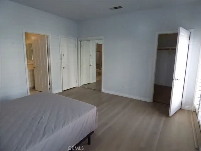 a big room with closet and wooden floor