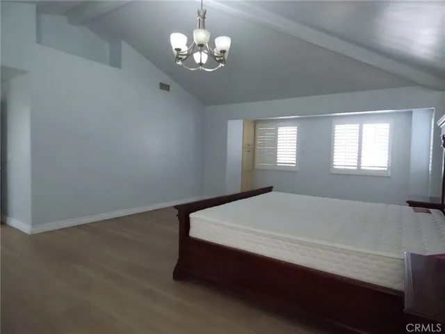 a spacious bedroom with a bed and a window