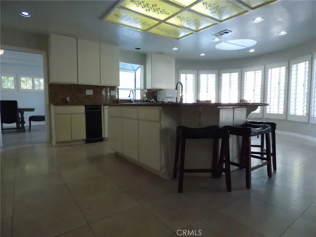 a kitchen with a table chairs sink and cabinets