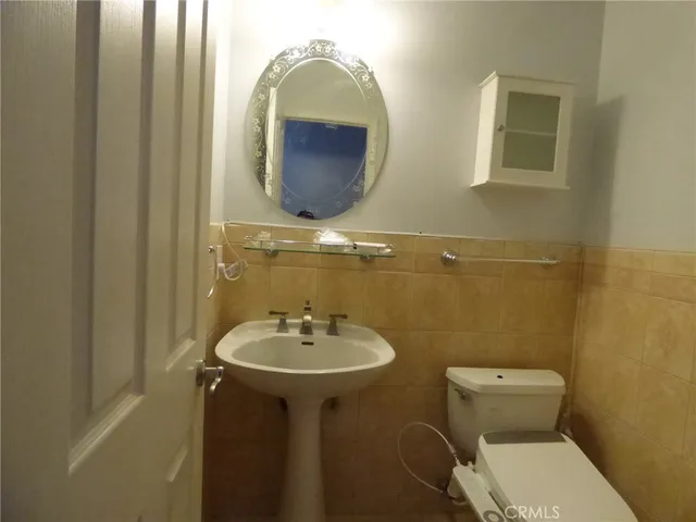 a bathroom with a toilet sink and mirror