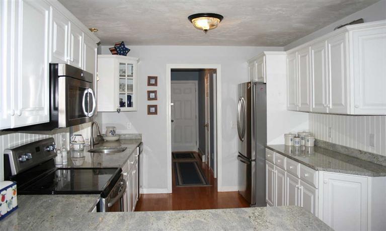28 Seavers Road Orleans, MA 02653 - Photo 6 of 16 a kitchen with stainless steel appliances granite countertop a refrigerator a stove and a sink
