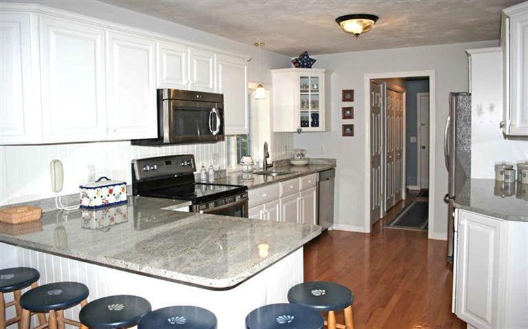 28 Seavers Road Orleans, MA 02653 - Photo 7 of 16 a kitchen with stainless steel appliances granite countertop a sink and a stove