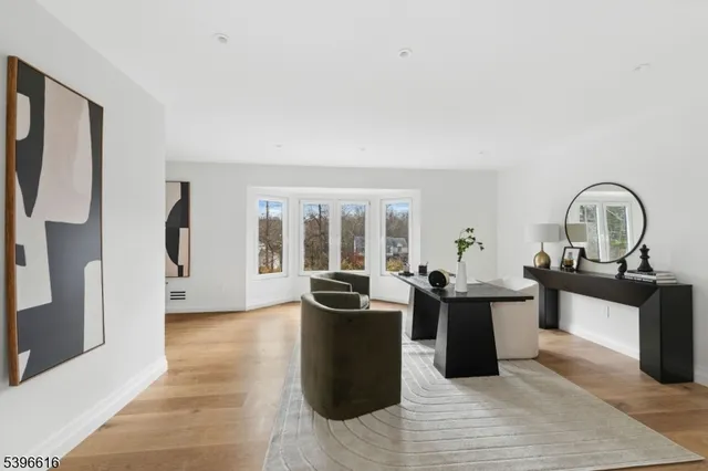 a dining room with kitchen island stainless steel appliances furniture a large window and a rug