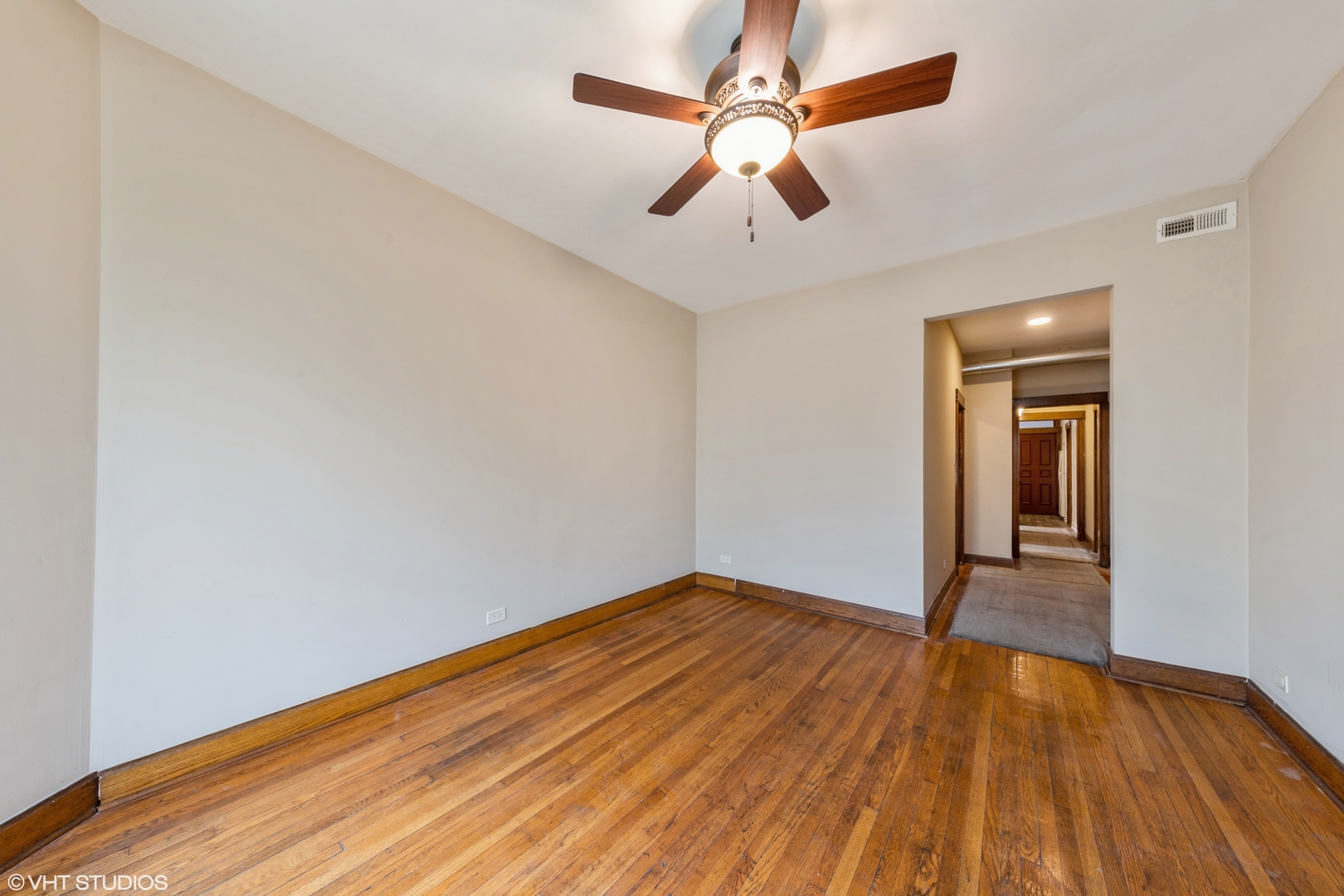 7806 South May Street Chicago, IL 60620 - Photo 12 of 20 an empty room with wooden floor chandelier fan and windows