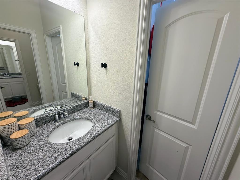 1109 Pinnacle Ridge Road Fort Worth, TX 76052 - Photo 30 of 40 a bathroom with a granite countertop sink and a mirror