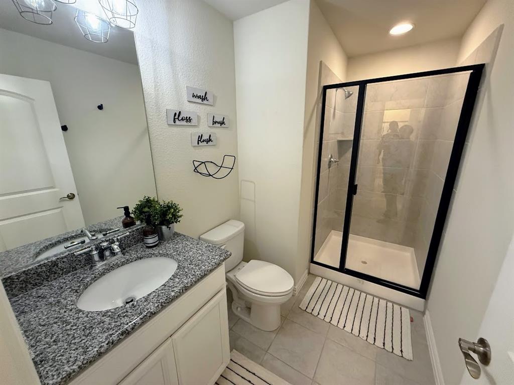 1109 Pinnacle Ridge Road Fort Worth, TX 76052 - Photo 33 of 40 a bathroom with a granite countertop sink toilet and shower a mirror
