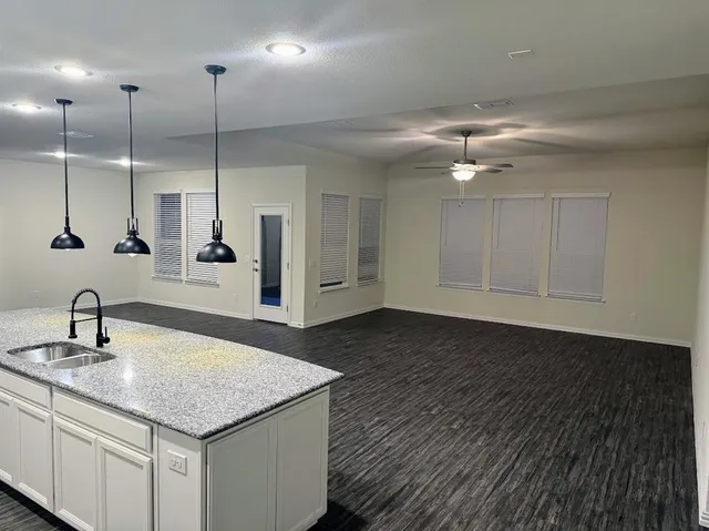 a kitchen with a sink chandelier and wooden floor