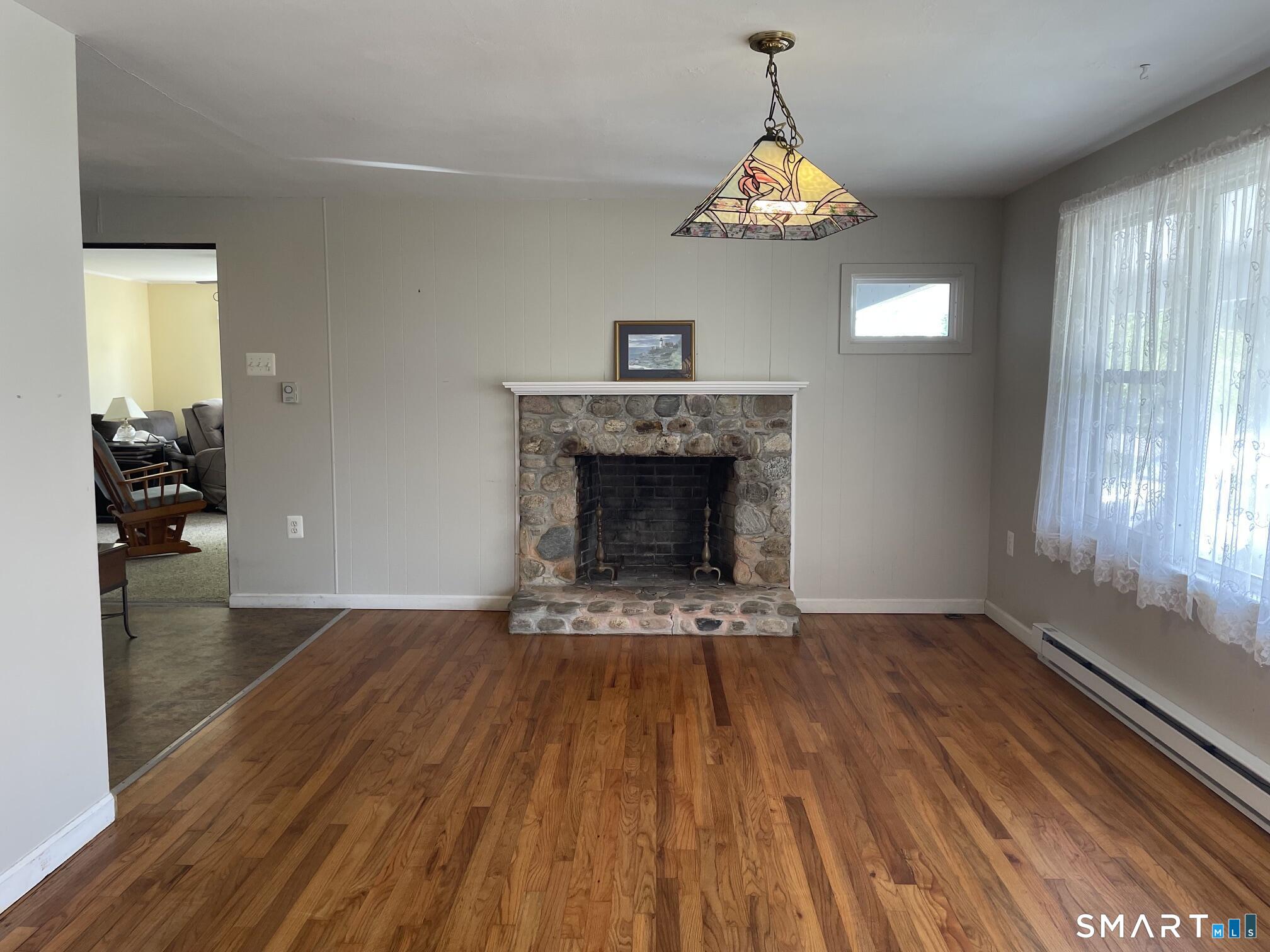 18 Old South Cove Road Old Saybrook, CT 06475 - Photo 9 of 40 a view of empty room with wooden floor fireplace and windows