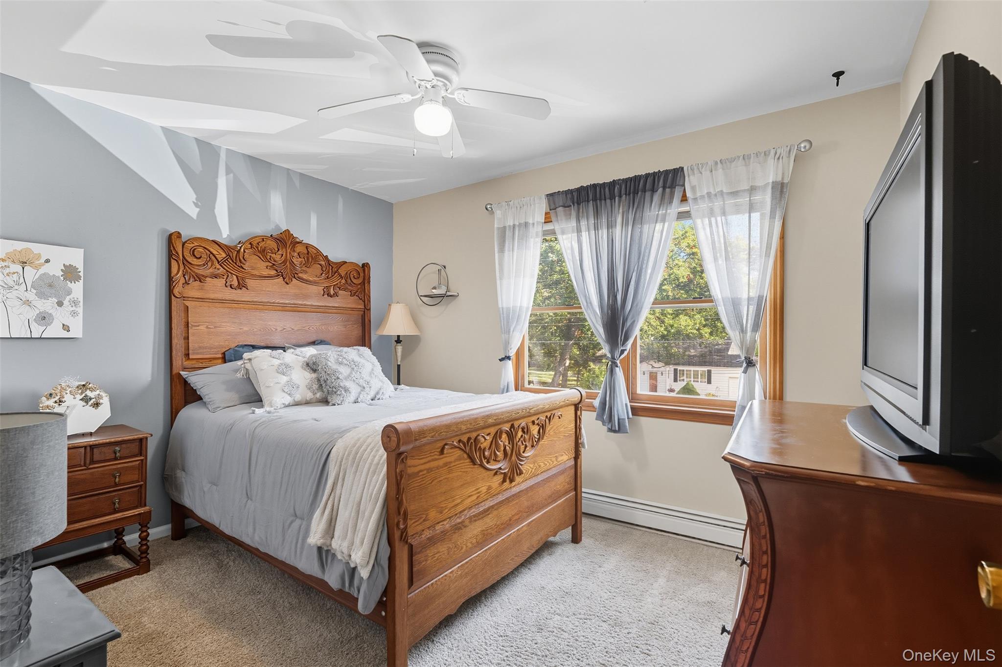 2747 Larkspur Street Yorktown Heights, NY 10598 - Photo 26 of 32 a bedroom with a bed flat screen tv and a large window