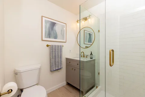 a bathroom with a toilet a sink and mirror