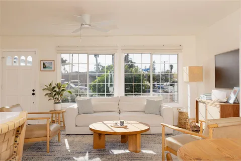 a living room with furniture a flat screen tv and a large window