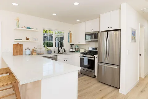 a kitchen with stainless steel appliances a refrigerator and a stove top oven
