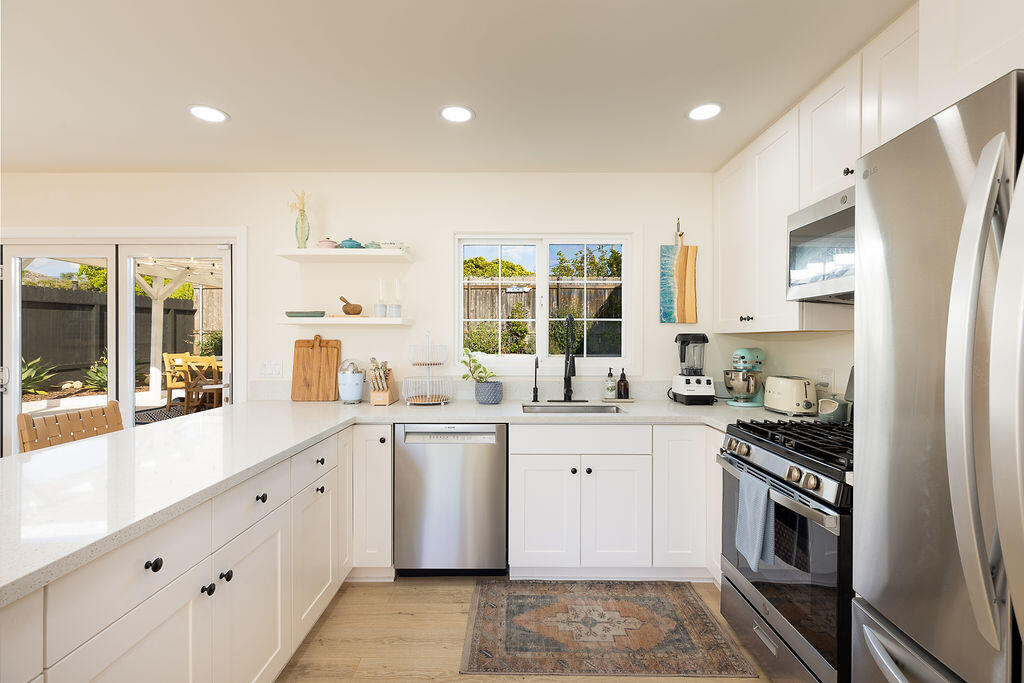 1430 Linhere Drive Carpinteria, CA 93013 - Photo 8 of 34 a kitchen with stainless steel appliances granite countertop a stove a sink and a refrigerator
